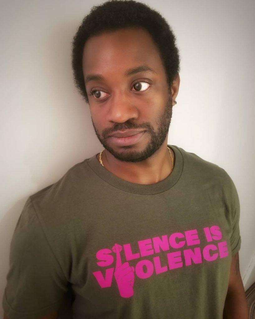 Shaun in a green and pink "Silence is Violence" shirt